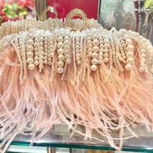 Ostrich feather pink with diamond ring clutch comes with strap.